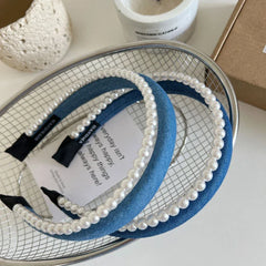 Blue denim headbands with pearl trim in a wire basket