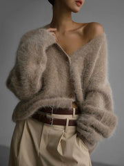 Model wearing a beige fuzzy V-neck button-up cardigan styled with light brown pants and a brown belt.