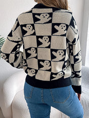 Back view of a woman wearing a black and white ghost print checkerboard knit sweater with blue jeans.