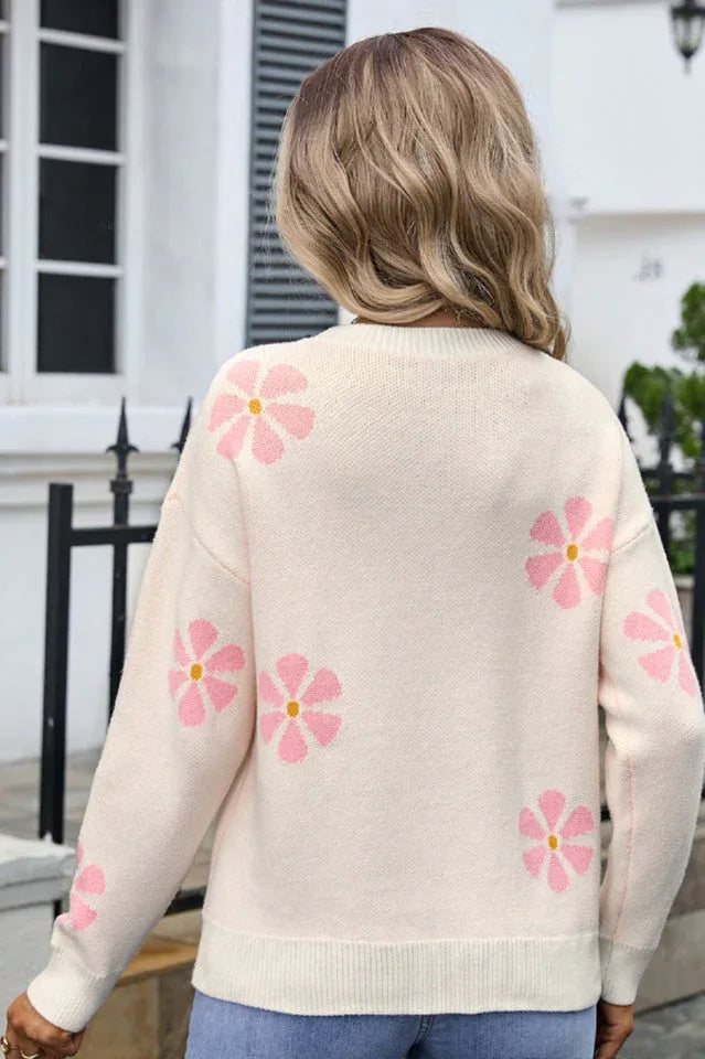 Back view of a woman wearing a cream-colored knit sweater with a pink floral print.