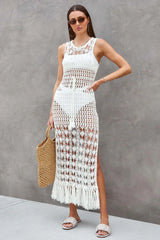 Full body shot of a woman in a white crochet knit maxi dress with a side slit and fringe hem.