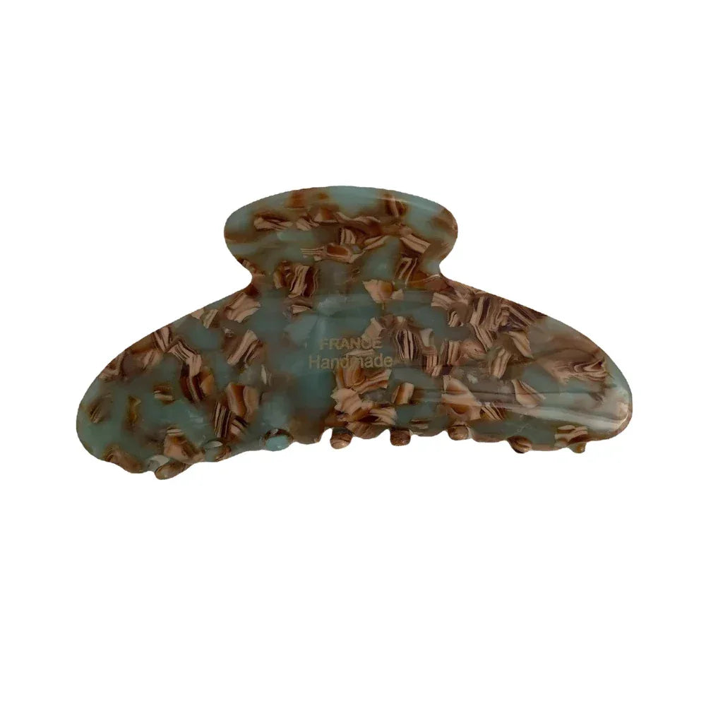 A single light blue and brown tortoiseshell patterned hair claw clip, made of acetate, with 'FRANCE Handmade' printed in gold.