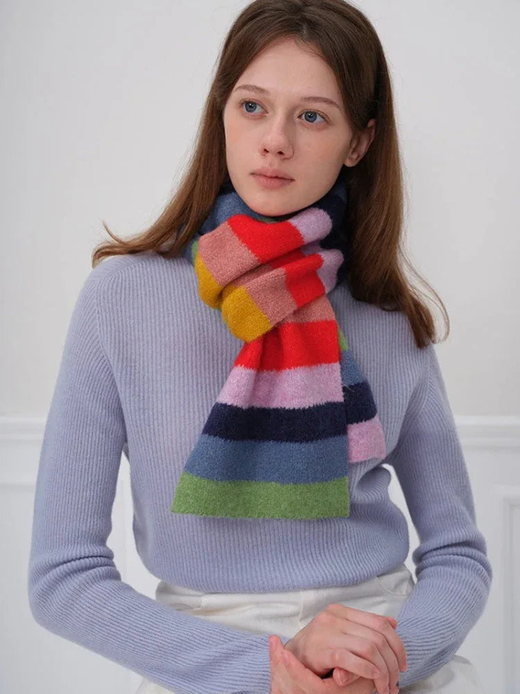 Woman wearing a blue sweater and a colorful striped scarf