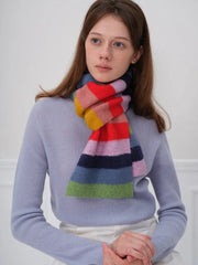 Woman wearing a blue sweater and a colorful striped scarf