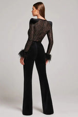Woman modeling a black sequined mesh top with feathered cuffs and black velvet flared pants from the back.