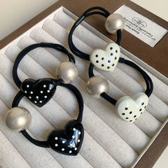 Set of heart-shaped hair ties, some white and some black, with silver beads
