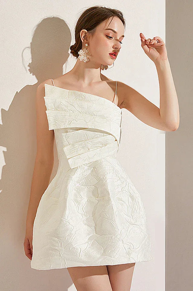 Close-up of a woman in a white asymmetrical neckline dress, showcasing the textured fabric.