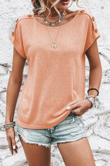 Front view of a woman in a peach short-sleeved t-shirt with button shoulder details.