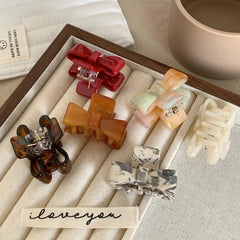 close-up of various bow claw clips displayed in a wooden tray
