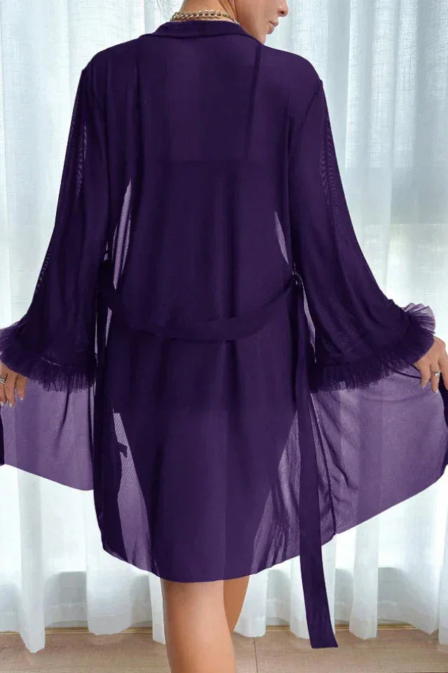 Back view of a woman in a purple sheer robe with ruffled cuffs and a tie waist
