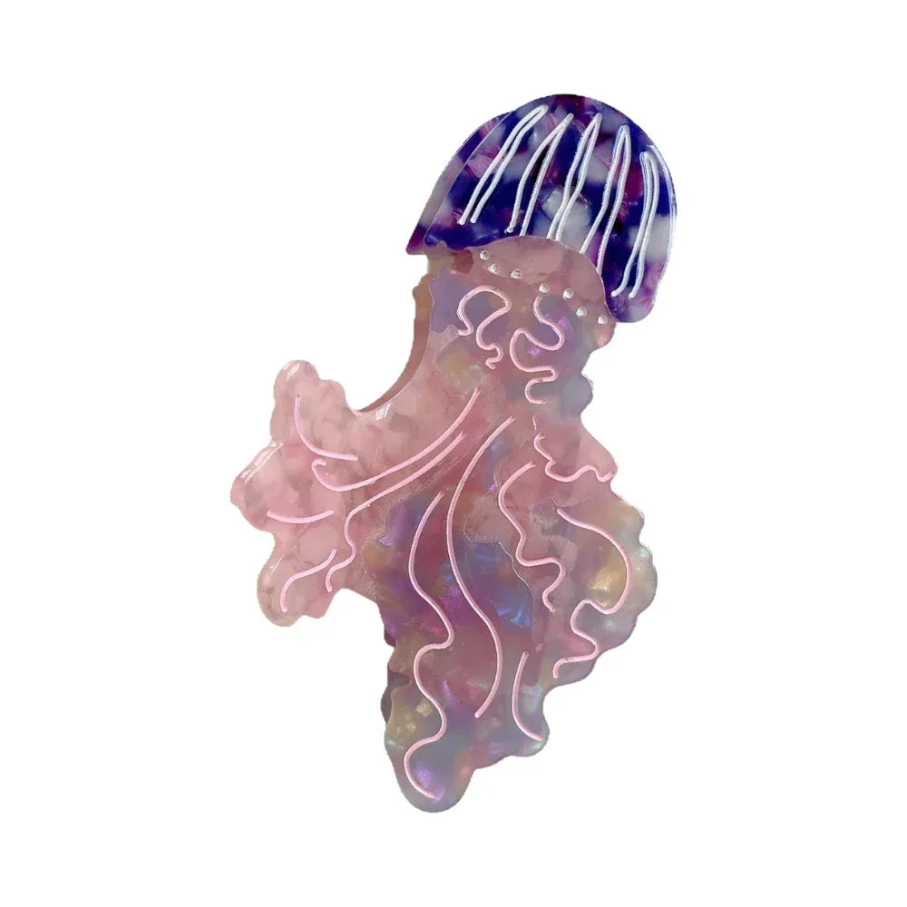 Pink and purple iridescent acrylic jellyfish hair clip with white swirling details and a striped bell.