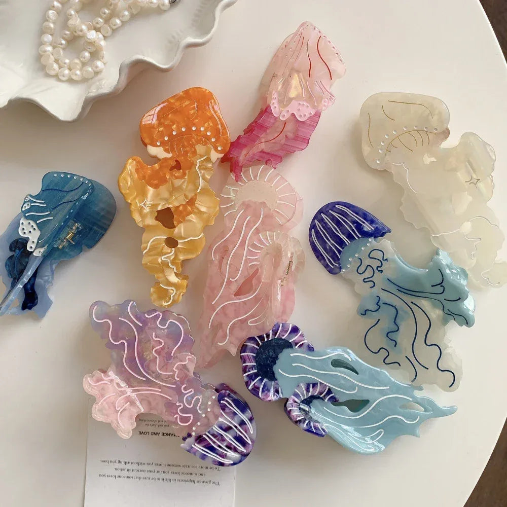 Overhead view of multiple acrylic jellyfish hair clips arranged on a white surface, showcasing different colors and designs.