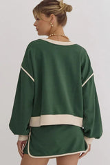 Back view of a woman wearing a green crew neck sweatshirt