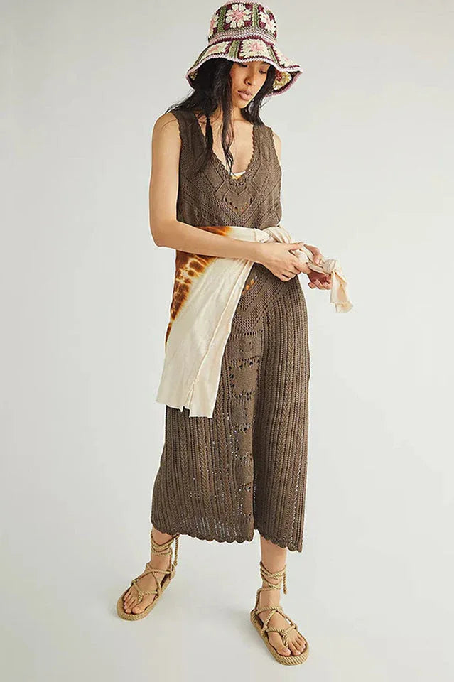 woman wearing a brown crochet knit midi dress, a tie-dye scarf, a bucket hat, and sandals