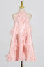 Mannequin displaying a pink halter dress adorned with fabric flowers and sparkling accents.