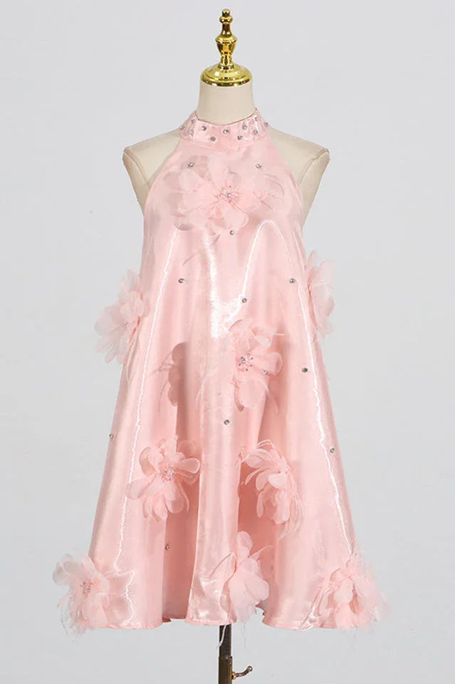 Mannequin displaying a pink halter dress adorned with fabric flowers and sparkling accents.