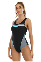 Woman wearing a black one-piece swimsuit with grey and blue color blocking