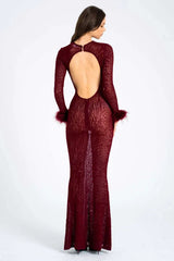 Woman wearing a long-sleeved, burgundy, animal print, sheer mesh dress with feathered cuffs and an open back, back view.