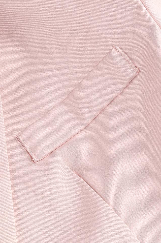 Close-up of the flap pocket detail on the pink blazer