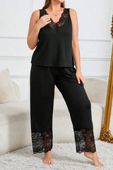 Woman wearing a black lace-trimmed pajama set standing.