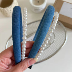 Close-up of a blue denim headband with pearl trim