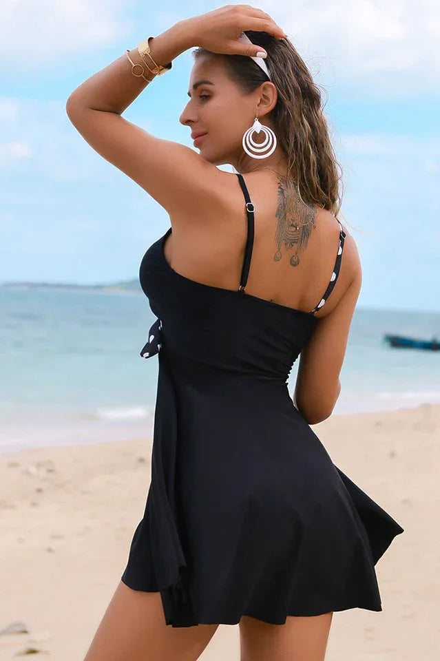 Woman from behind wearing a black swimdress with striped accent