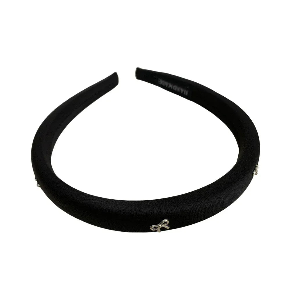Black padded headband with bow embellishments