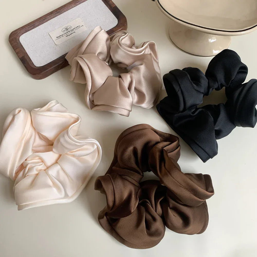 collection of satin scrunchies in brown, black, beige, and cream