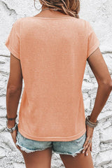 Back view of a woman in a peach short-sleeved t-shirt with button shoulder details.