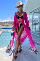 Woman wearing a pink leopard print trim maxi duster over a black bikini