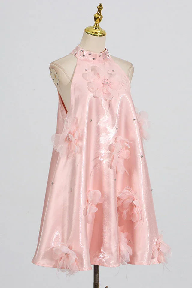 Side view of a pink halter dress on a mannequin, showcasing its A-line silhouette and floral embellishments.