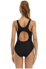 Back view of a woman in a black one-piece swimsuit with a round cutout