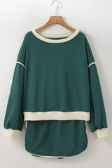 Green crew neck sweatshirt with cream trim hanging on a wooden hanger
