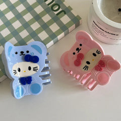 Blue and pink character hair claw clips arranged on a white surface