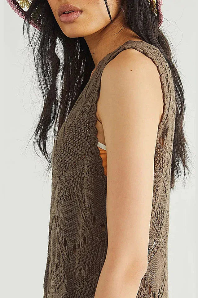 close-up of a woman's shoulder and arm wearing a brown crochet knit midi dress