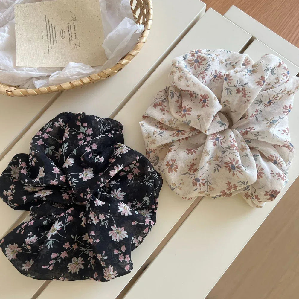 Two floral print chiffon scrunchies on a white surface