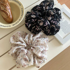 Two floral print chiffon scrunchies next to a baguette