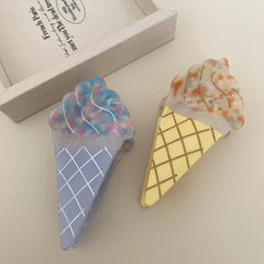 Two ice cream cone hair clips, one blue and one yellow, side by side on a white surface.