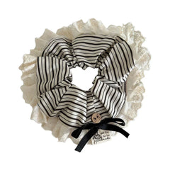 A close-up view of a black and white striped scrunchie with a lace trim and black bow.