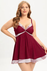 Plus-size burgundy swim dress with polka dot trim and twisted front