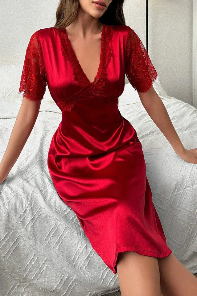 Woman sitting on a bed wearing a red satin nightgown