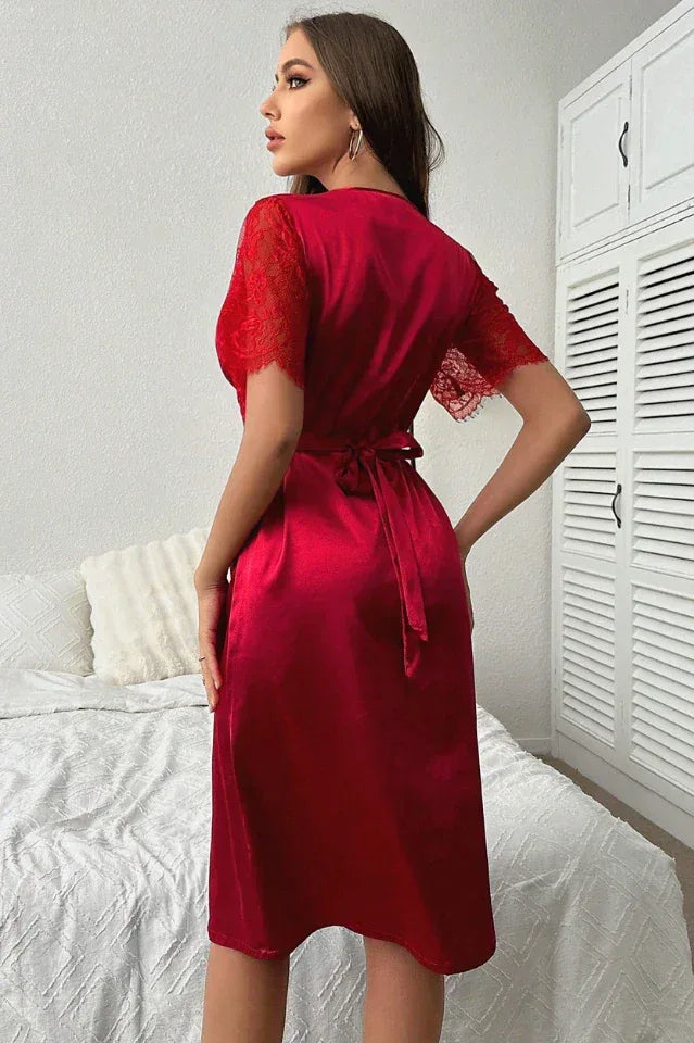 Back view of a woman in a red satin nightgown with a tie waist