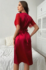 Back view of a woman in a red satin nightgown with a tie waist