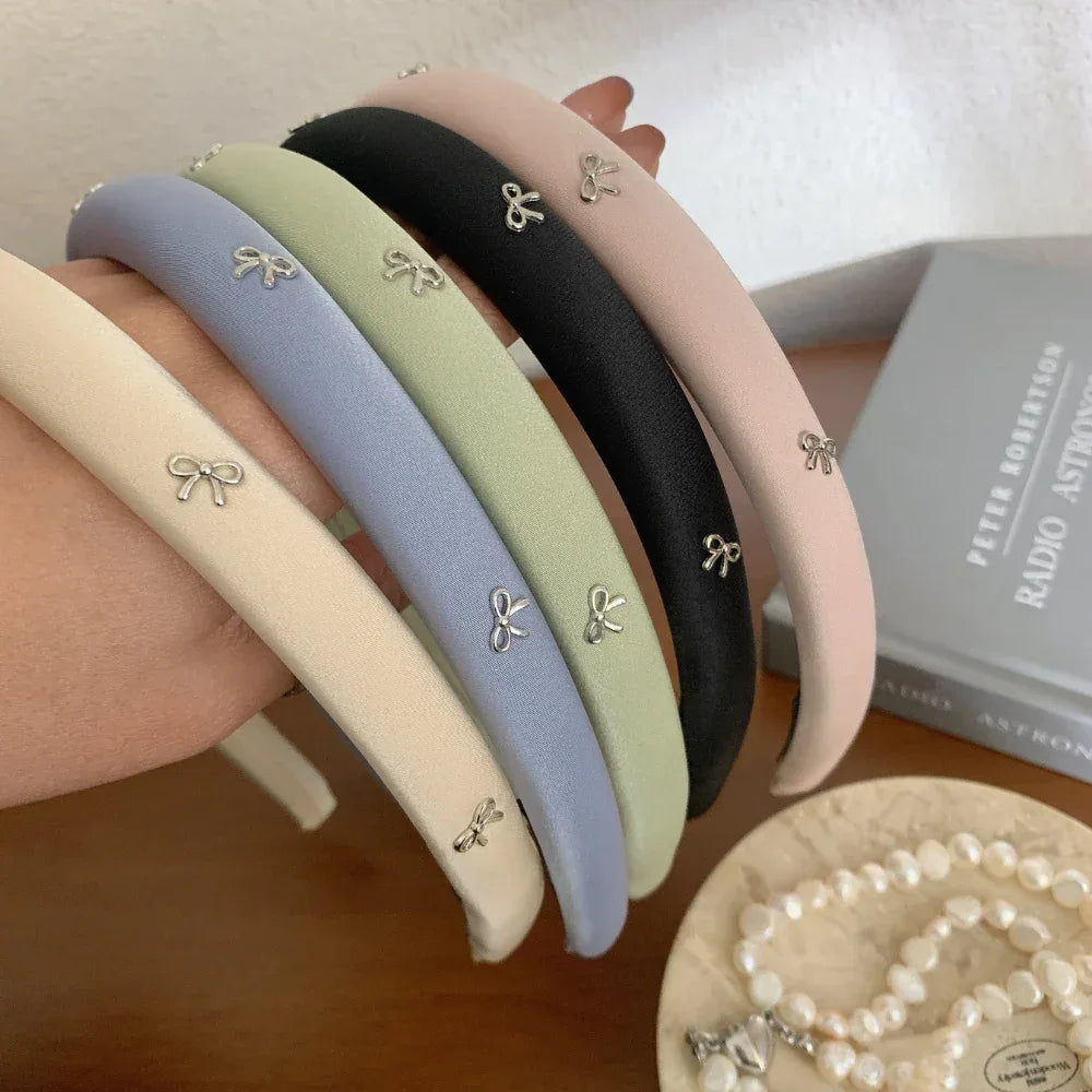 Close-up of pastel padded headbands with bow charms being held