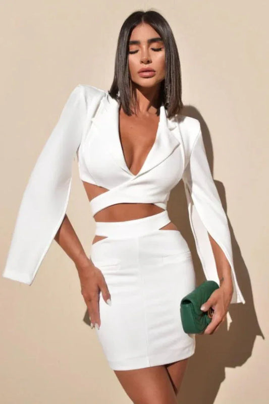 Woman wearing a white two-piece set with cut-out details and bell sleeves.