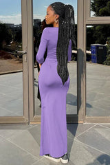 back view of a woman wearing a long purple ruched dress with a flare hem
