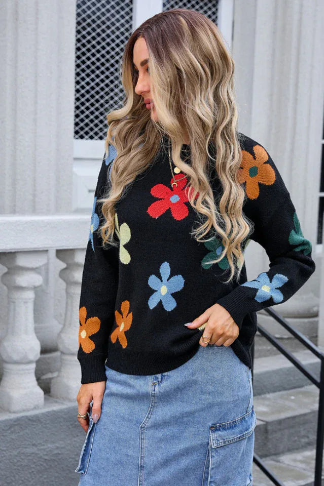 Close-up of a woman wearing a black long-sleeve sweater with a colorful floral print.