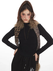 Close-up of a model wearing a black long-sleeve top and a black maxi skirt with a drawstring waist and white star graphics, with a multi-patterned scarf around her neck and hands on hips.