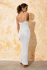 Back view of a woman wearing a white knit maxi dress with spaghetti straps, showcasing the sheer knit pattern.