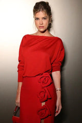 close-up of a woman wearing a red floor-length skirt with rose embellishments on the side